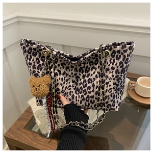 Dettaglio della borsa tote leopardata con catena dorata e ciondolo a orsetto