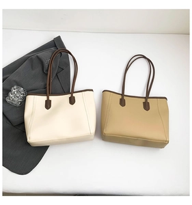 Minimalist tote bags in off-white and khaki colors featuring brown leather handles