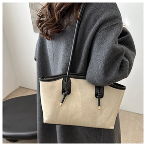 Detail view of large cream and black tote bag with Fashion text and slender straps