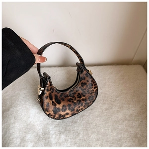 Detail of mini leopard print crescent bag with gold zipper and textured faux leather finish