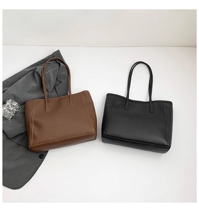 Detail of minimalist leather tote bags in brown and black with premium matte texture