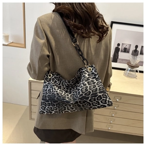 Hobo shoulder bag featuring leopard print, thick black chain, and leather strap detail