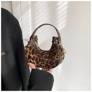 Close-up of leopard print crescent bag with gold zipper and stylish metal hardware detail