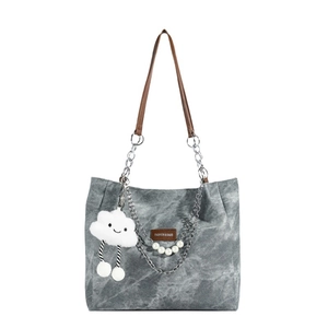 Chic grey canvas tote bag with brown leather straps and pearl chain detail on white background