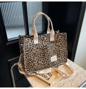 Detail of leopard print tote bag with adjustable shoulder strap and woven handles