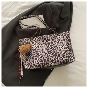 Dettaglio della borsa tote leopardata con catena metallica e ciondolo a forma di orso