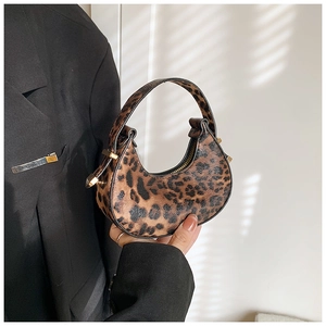 Detail of leopard print crescent bag with elegant gold metal hardware and smooth PU texture