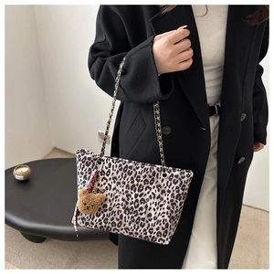 Dettaglio della borsa tote leopardata con tracolla a catena e ciondolo a orsetto