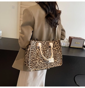 Detailed side view of large leopard print tote bag with adjustable strap and front pocket