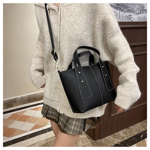 Détails du sac en cuir noir avec coutures contrastées blanches et fermoirs argentés