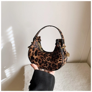 Detail of trendy leopard print crescent underarm bag with gold zipper and handle