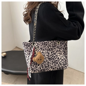 Dettaglio borsa tote leopardata con tracolla a catena e ciondolo a forma di orsetto