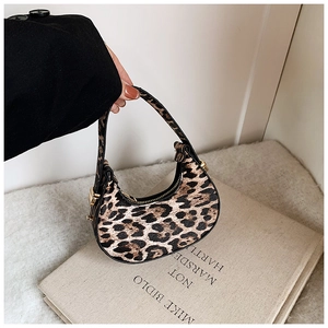 Close-up of crescent leopard print handbag with golden metal buckles and zipper detail
