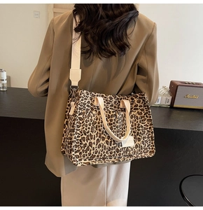 Macro shot of large leopard print canvas tote bag with adjustable shoulder strap and tag
