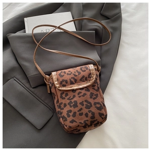 Detail shot of leopard print mini crossbody bag with suede texture on a stylish blazer