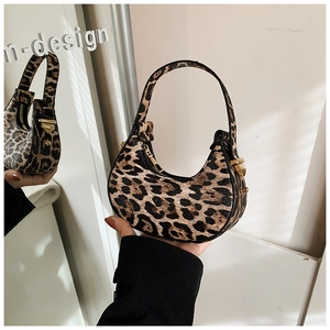Detailed view of leopard print crescent bag with gold hardware and smooth handle