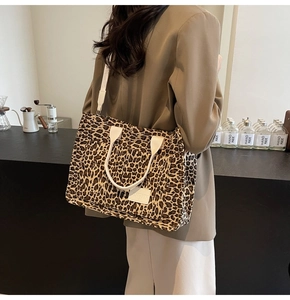 Detail of a large leopard print canvas tote bag with adjustable cream shoulder straps