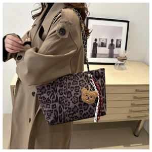 Dettaglio della borsa tote leopardata con catena dorata e ciondolo a forma di orso