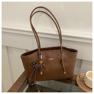 Detail of vintage brown tote bag featuring gold lettering and a unique key tassel pendant