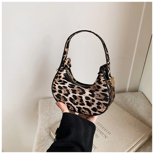 Detail of leopard print crescent bag featuring gold hardware and sturdy top handle