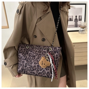Dettaglio della borsa tote leopardata con tracolla a catena e ciondolo a forma di orso