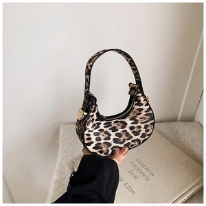 Close-up of leopard print hobo bag with top handle and metal zipper on knit background