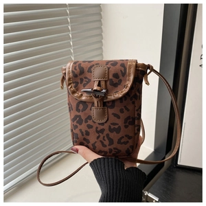 Detail of leopard print crossbody phone bag with vintage horn button and leather trim