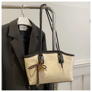Detailed macro view of the cream and black leather tote bag with a fashion print