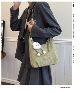 Detail of light green ruched nylon crossbody bag with a cute cloud plush charm