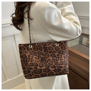 Borsa tote leopardata retrò con tracolla a catena dorata indossata da una modella