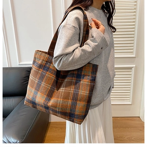 Detail of tartan pattern shoulder bag showing large capacity and winter fabric texture