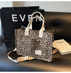 Detailed view of leopard print tote bag with front pockets and adjustable shoulder strap