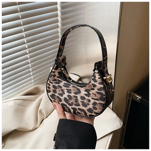 Close-up of leopard print hobo bag featuring golden hardware and a curved moon shape