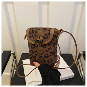 Detail of leopard print crossbody phone bag with horn toggle button and brown piping