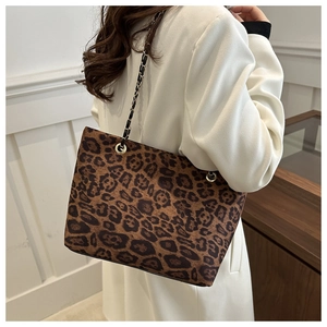 Dettaglio borsa shopper leopardata con tracolla a catena e inserti in pelle intrecciata