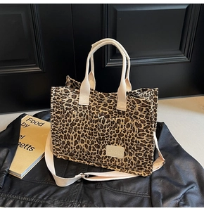Detail of leopard print canvas tote bag featuring front pockets and woven straps