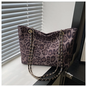 Dettaglio della borsa tote leopardata con catena dorata in luce naturale soffusa