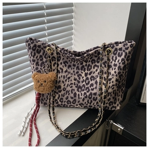 Dettaglio borsa tote leopardata con tracolla a catena e ciondolo a forma di orso