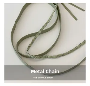 Detail shot of light green leather shoulder strap and polished silver hardware chain