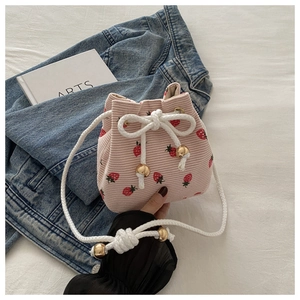 Detailed close-up of pink corduroy drawstring bag with vibrant red strawberry patterns