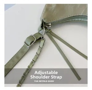 Detail of adjustable leather strap and silver chain on a sage green tote handbag