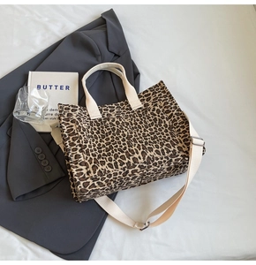 Detail of leopard print canvas tote bag with off-white handles and front pocket