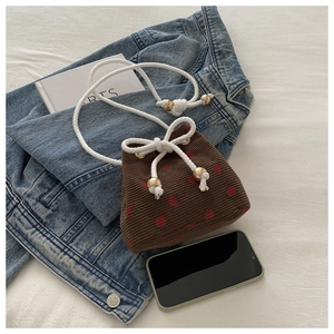 Detail of brown corduroy bucket bag with strawberry print and gold bead drawstring