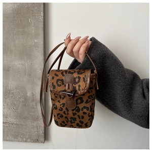 Detailed close-up of leopard print crossbody phone bag with horn toggle closure
