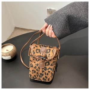 Close-up of leopard print phone bag with brown trim and vintage horn button closure