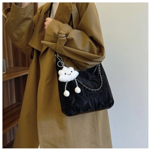 Close-up of black pleated shoulder bag with silver chain and white cloud charm
