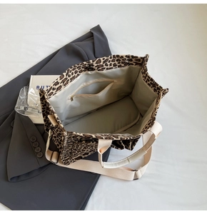 Detailed interior of leopard print tote bag with zipper pocket and magnetic closure