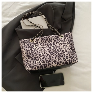 Dettaglio borsa shopper leopardata con tracolla a catena oro e fondo in pelle nera