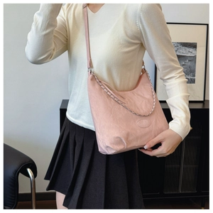 Detail of pink shoulder bag featuring soft textured fabric and silver chain strap