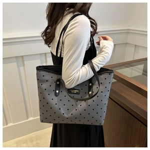 Détail du sac cabas en toile grise à pois noirs et anses en cuir avec rivets dorés